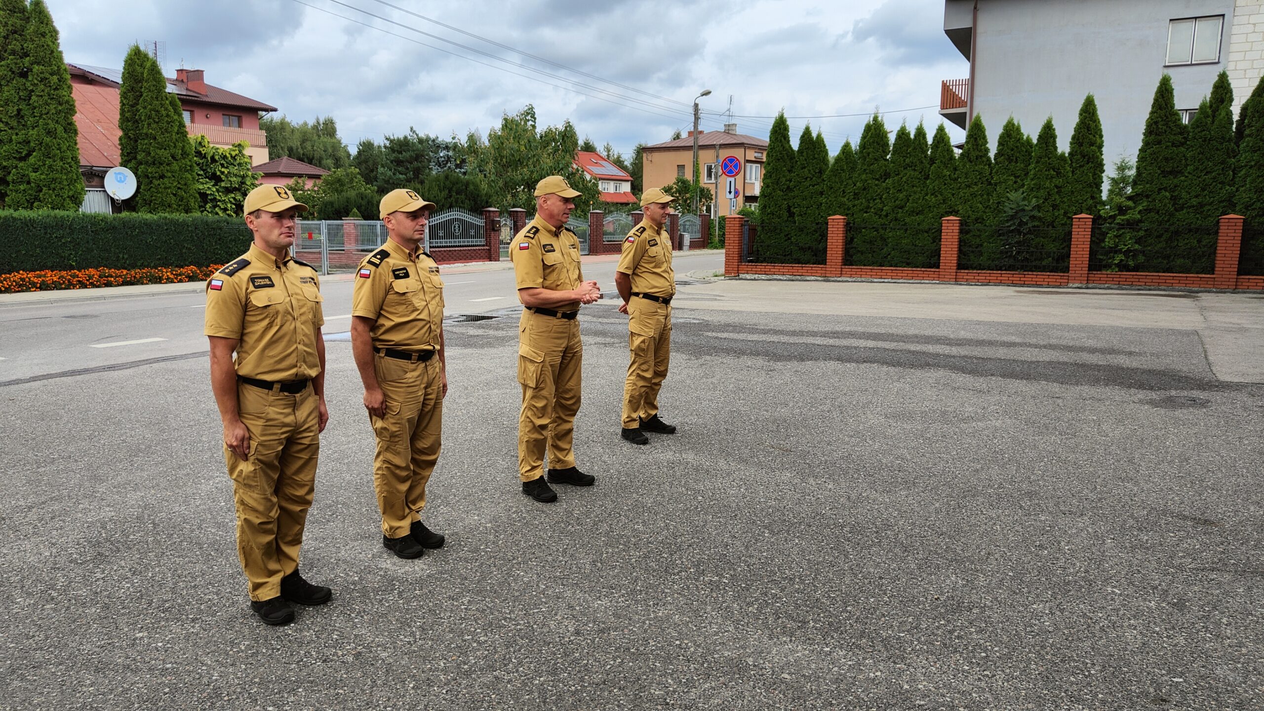 Czterech strażaków stoi w szeregu. Przemawia Komendant Powiatowy PSP w Parczewie