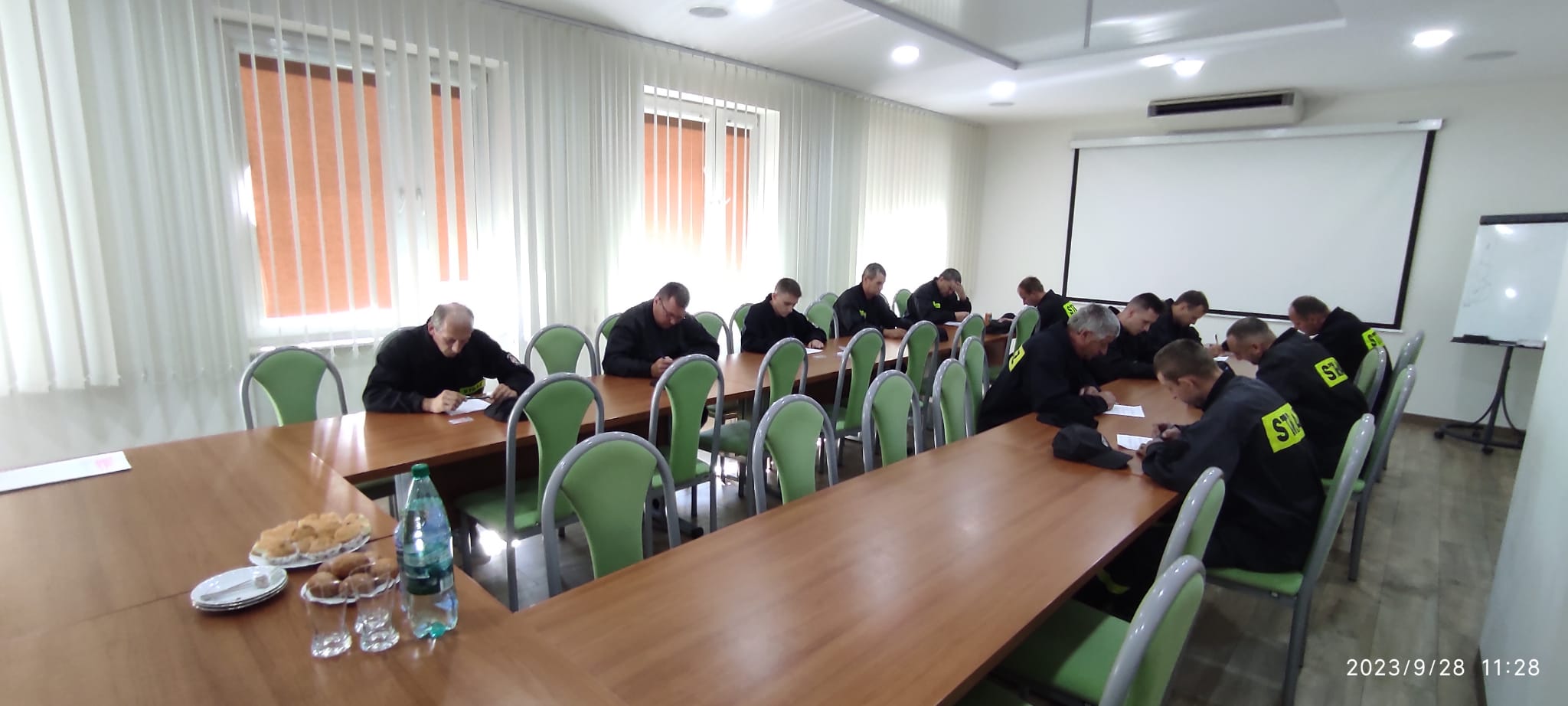 Zdjęcie przedstawia kursantów podczas pisemnego egzaminu. Zdjęcie wykonano w sali konferencyjnej Komendy Powiatowej PSP w Parczewie